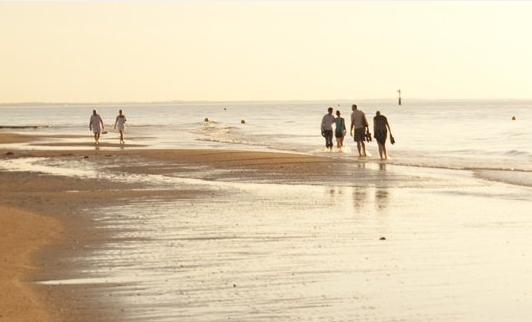 Spaziergänger am Strand in der Normandie