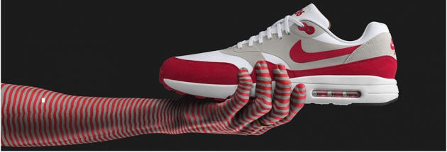 Eine rot weiß gestreifte Hand hält einen Nike Schuh in derselben Farbkombination