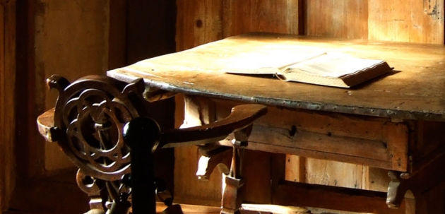 Holzstuhl an einem Holztisch mit Buch 