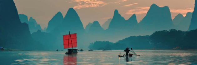 Reiseziel Asien - See vor Berglandschaft mit traditionellen Booten