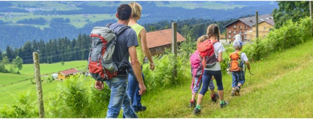 Familie mit Rücksäcken in den Bergen beim Wandern